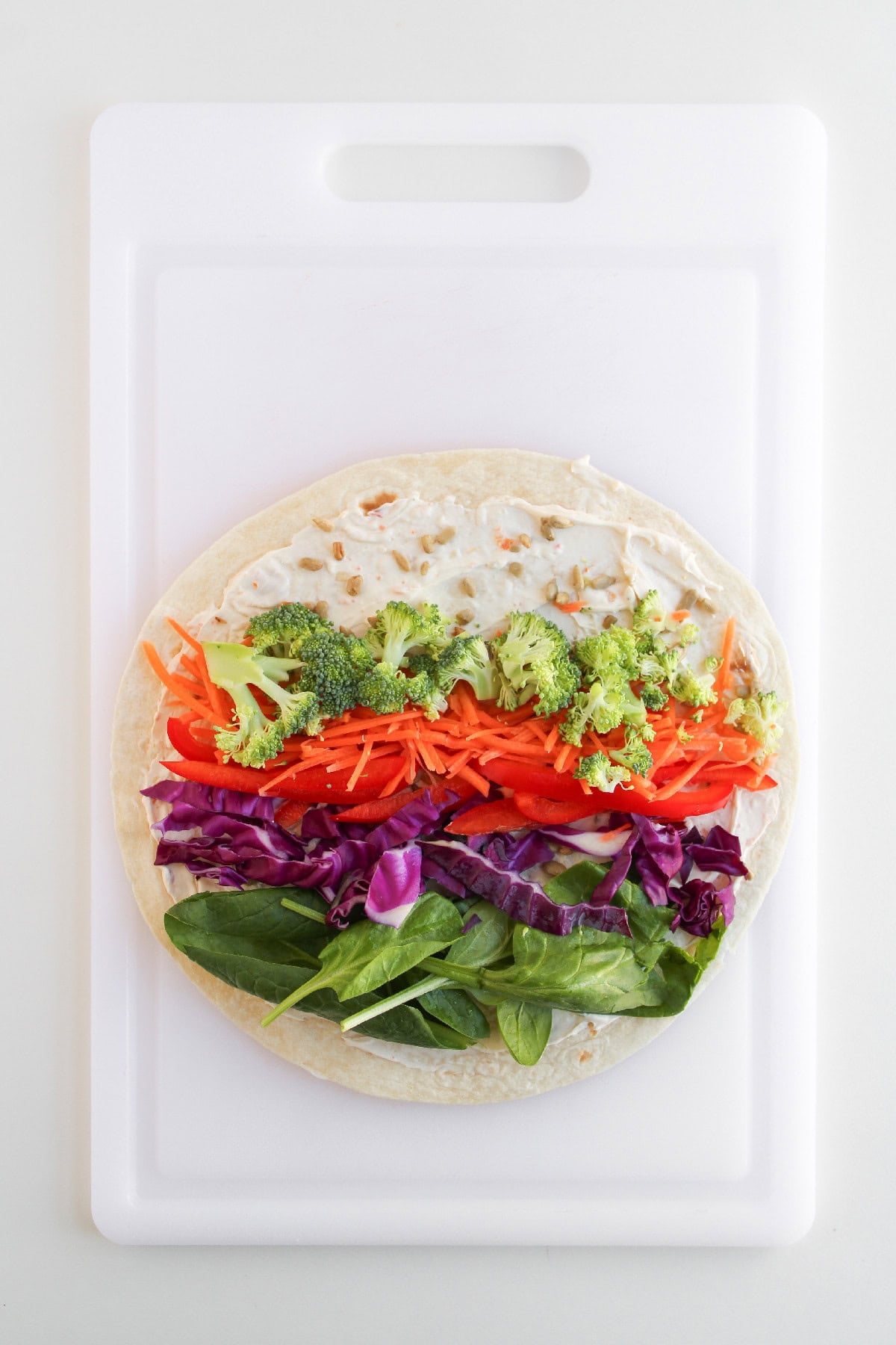 Fresh vegetables layered on a tortilla with creamy filling for veggie pinwheels.