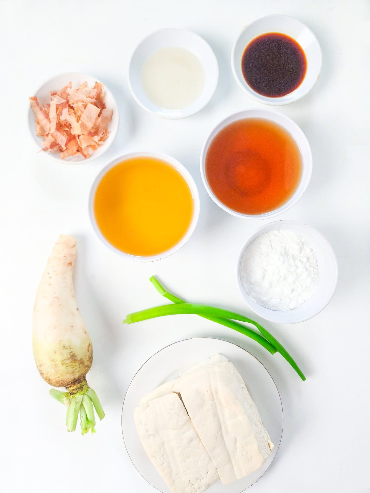 Alt: Assorted vegetables and sauces for veggie chopsticks, including tofu, radish, spring onions, and dipping sauces.
