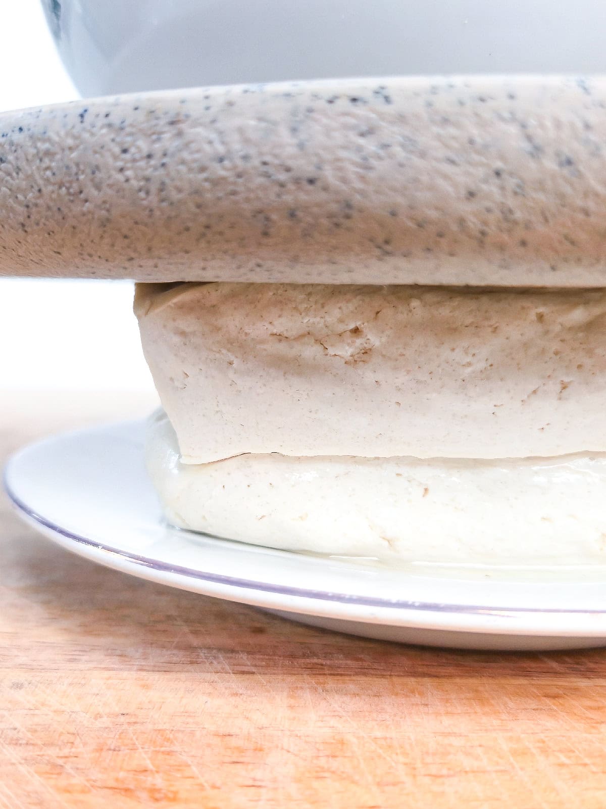 Pressing tofu with a heavy plate to remove excess moisture before frying.