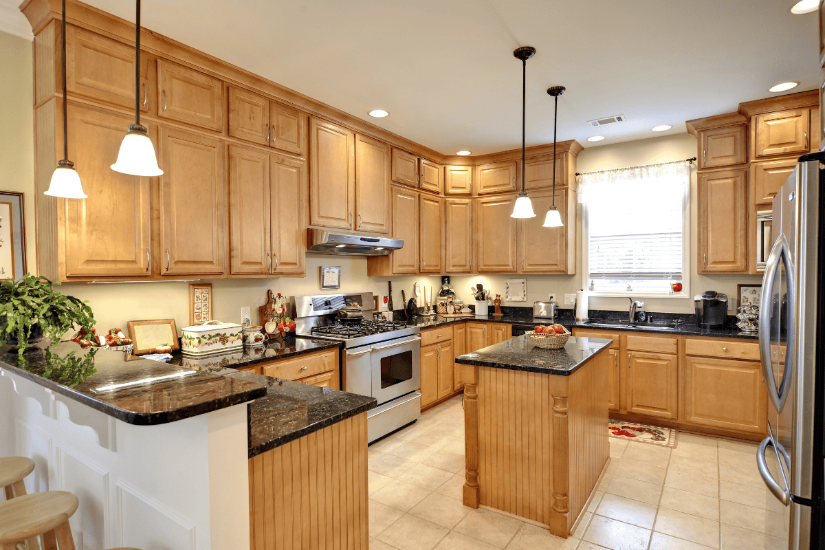 A warm, spacious kitchen with bamboo cabinets, granite countertops, and modern appliances.