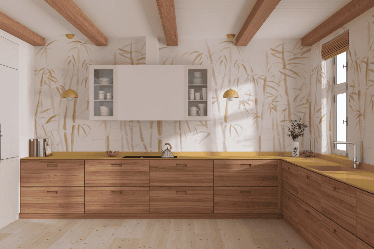 A modern kitchen with wooden lower cabinets, mustard-yellow countertops, bamboo-patterned wallpaper, exposed ceiling beams, and soft pendant lighting.