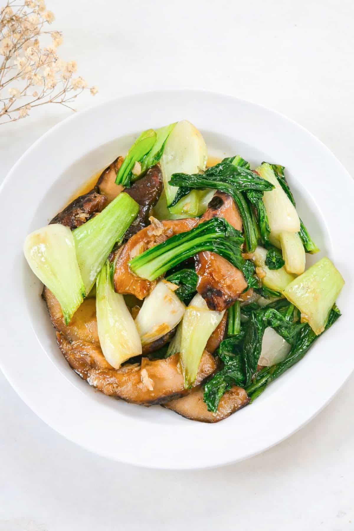 Bok choy mushroom stir fry with tender greens and sliced shiitake mushrooms in a bowl.