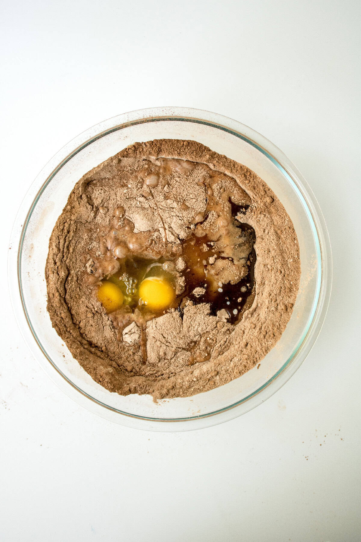 Eggs and liquid ingredients added to the center of dry chocolate cake batter before mixing.