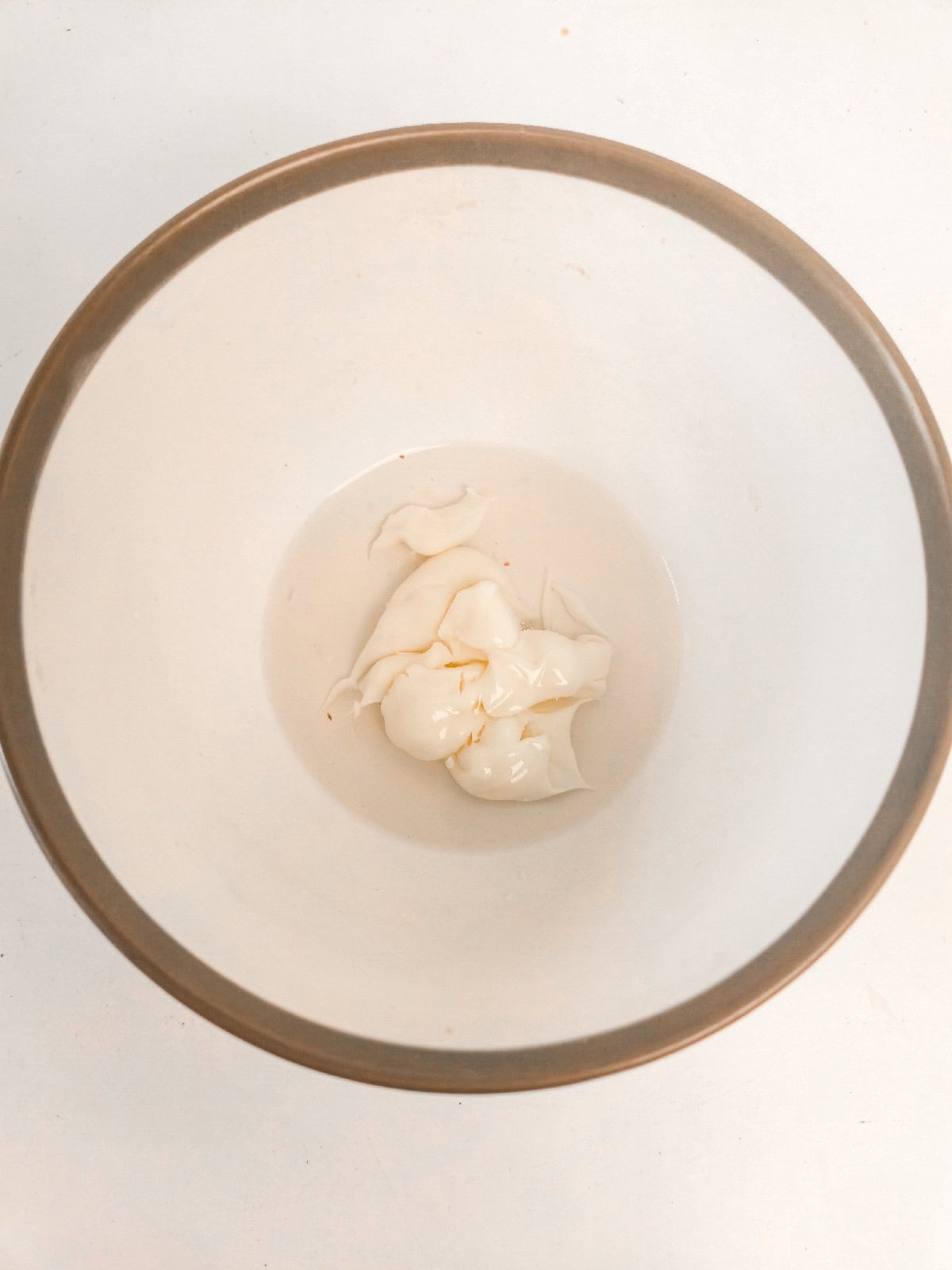 Cold water and mayo in a bowl used for making light tempura batter.