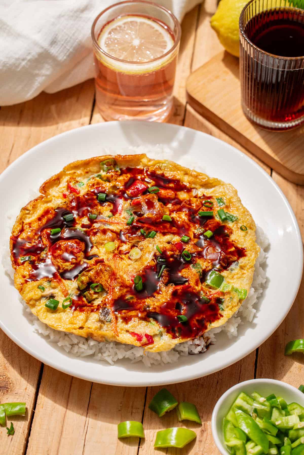 Close-up of vegetable egg foo young with glossy Chinese brown gravy and fresh scallions.