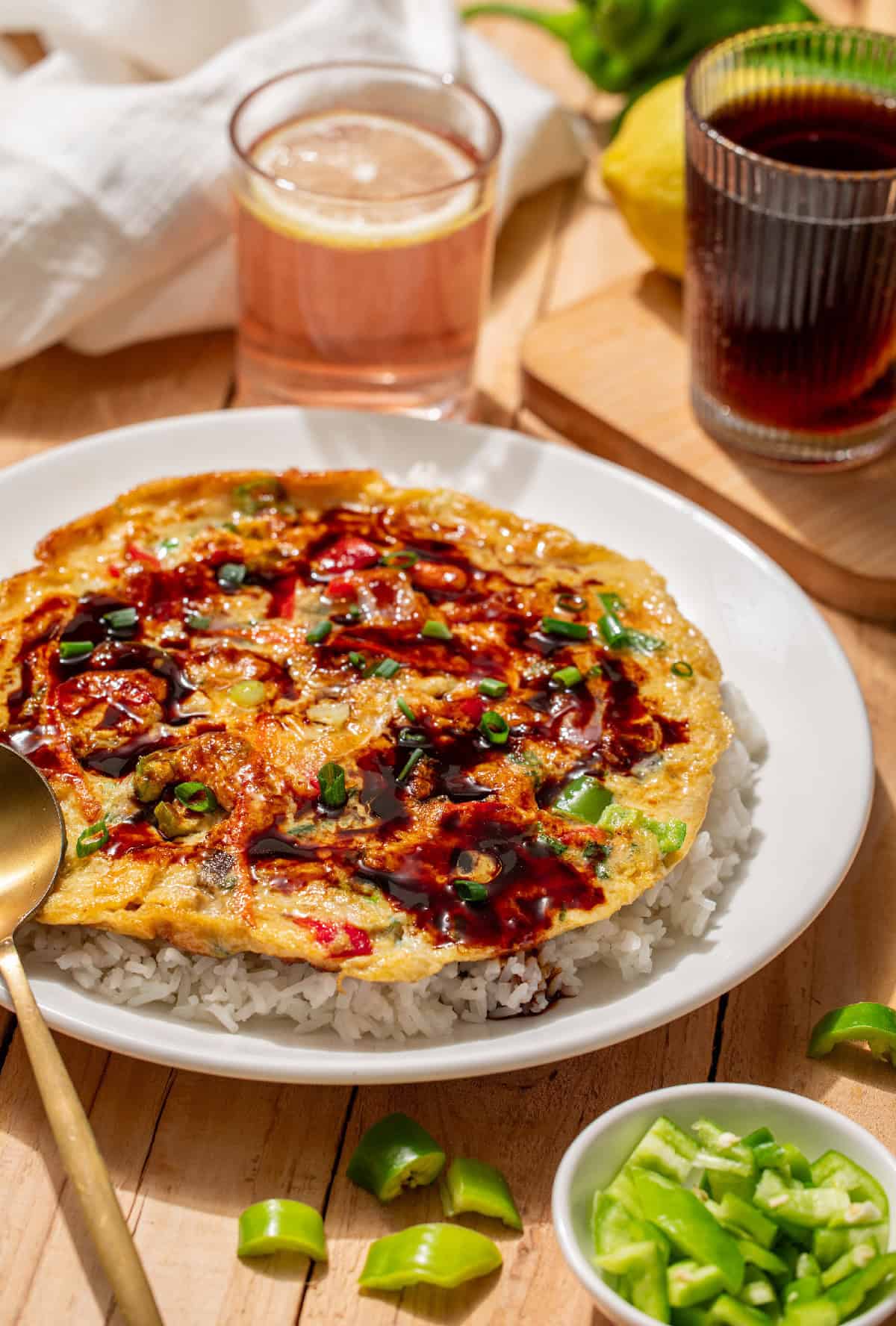 Close-up of vegetable egg foo young with glossy Chinese brown gravy and fresh scallions.