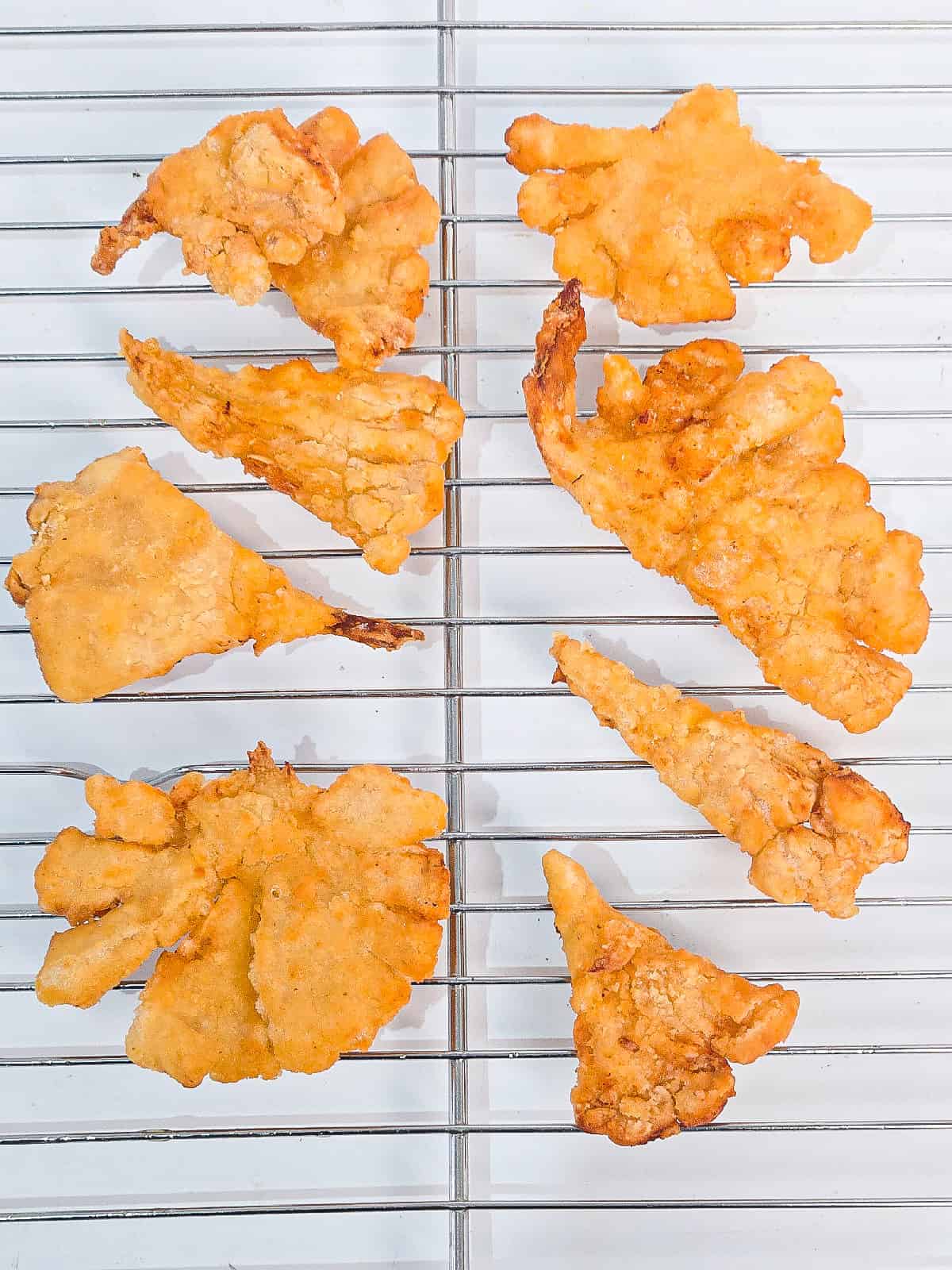 Crispy air fryer oyster mushrooms resting on a wire rack after cooking.