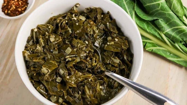 Braised collard greens served in a bowl with onions and seasoning.