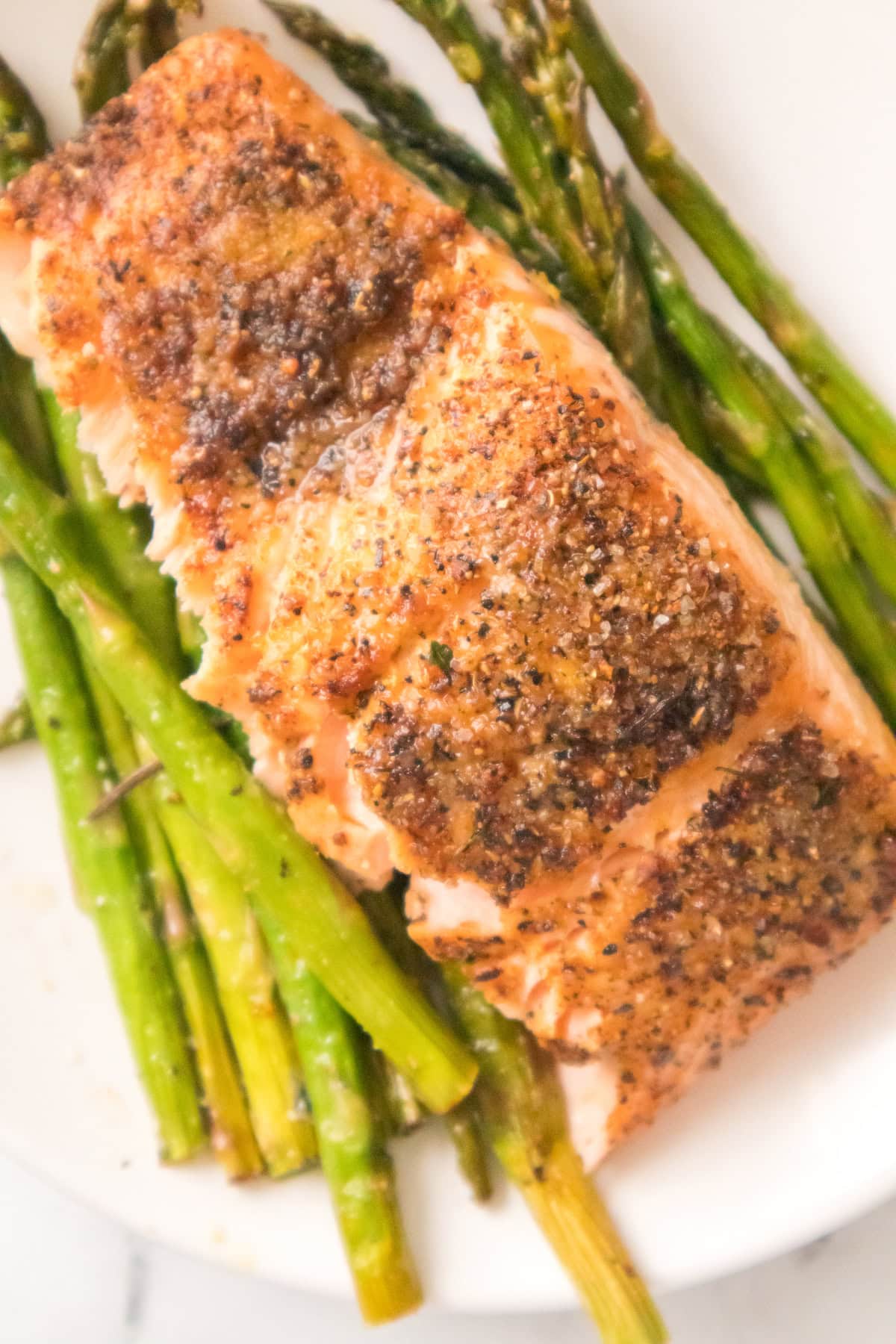 Juicy air fryer salmon and asparagus with seasoning and roasted texture.