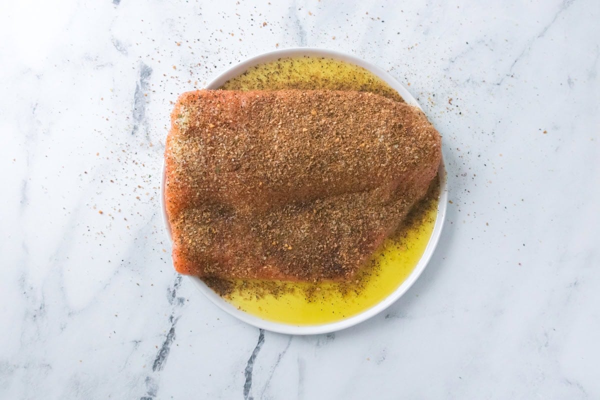Salmon fillet seasoned with spices and olive oil prepared for air fryer salmon and asparagus.