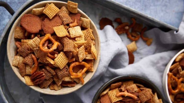 Homemade Chex Mix snack with cereal, pretzels, and nuts coated in buttery seasoning.