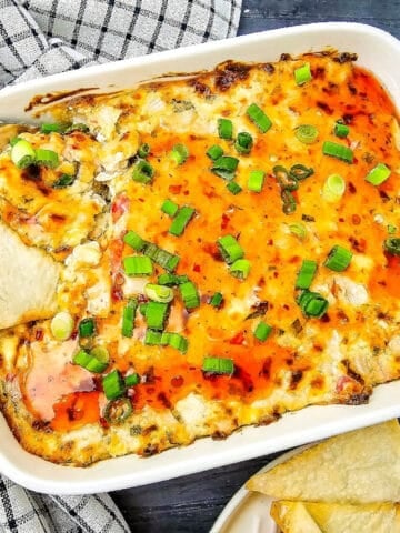 Crab Rangoon dip baked until golden and topped with sweet chili sauce and green onions, served with wonton chips.