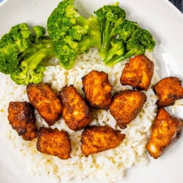 Air fryer salmon bites served over white rice with steamed broccoli in a bowl.