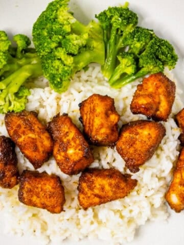 Air fryer salmon bites served over white rice with steamed broccoli in a bowl.
