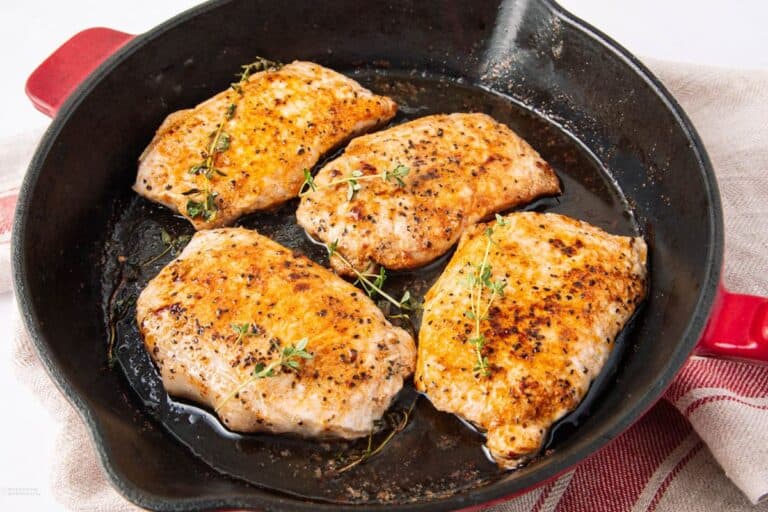 Boneless pan fried pork chop in a pan.