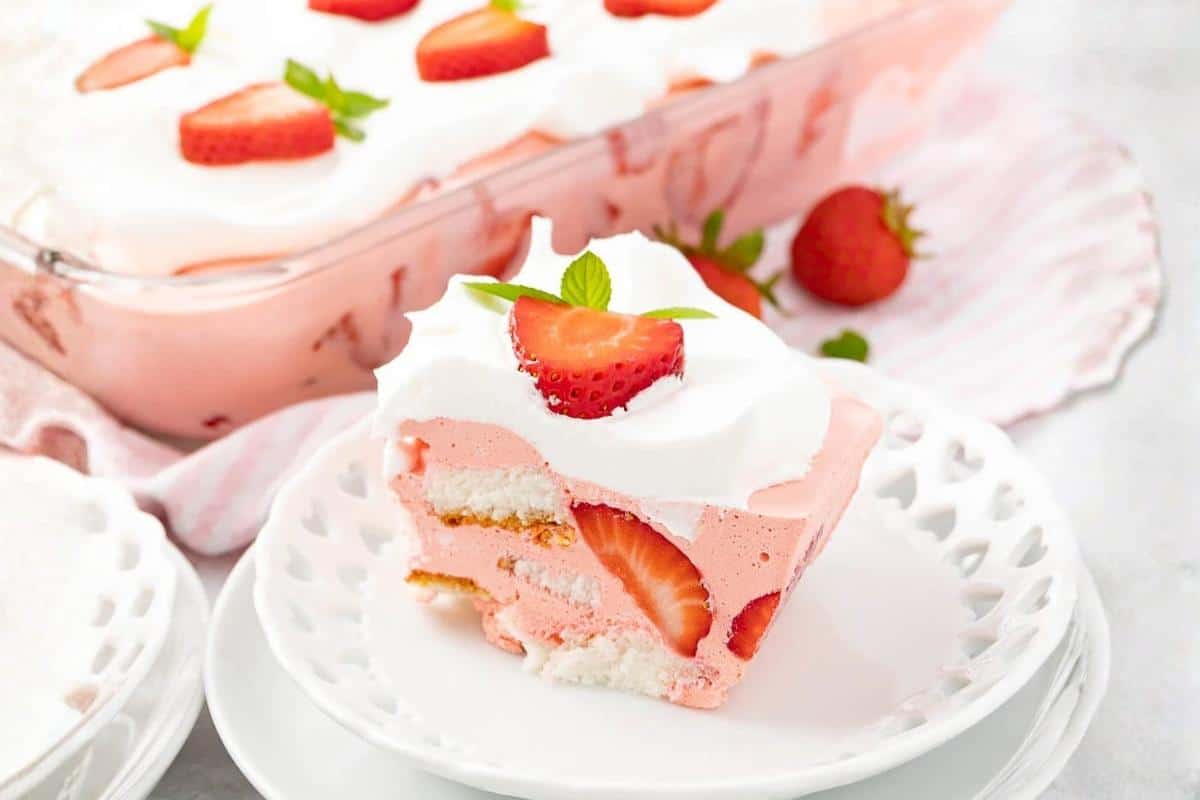 Angel food cake topped with strawberries and whipped cream.