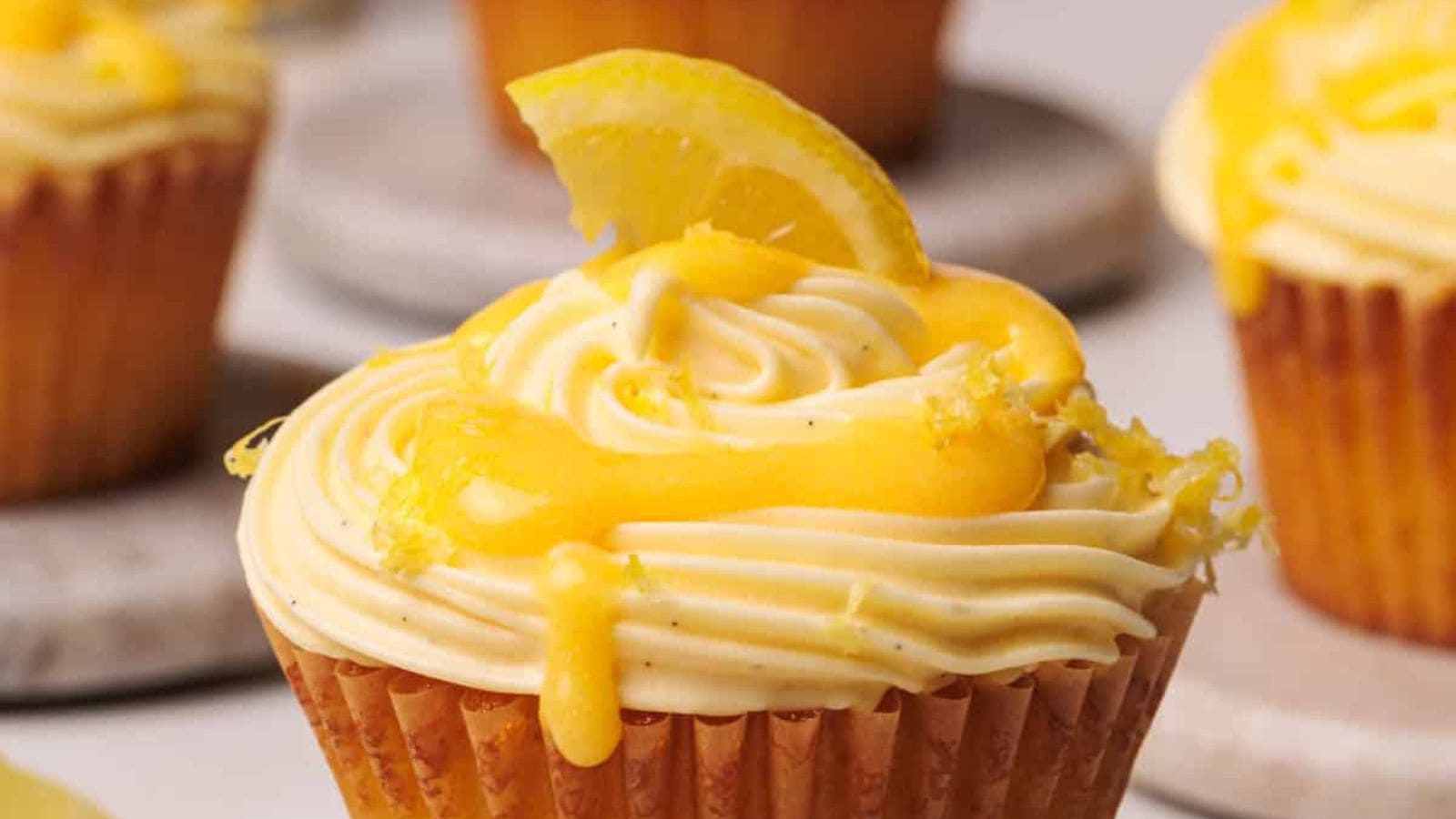 Soft lemon cupcakes topped with smooth frosting and fresh citrus zest.