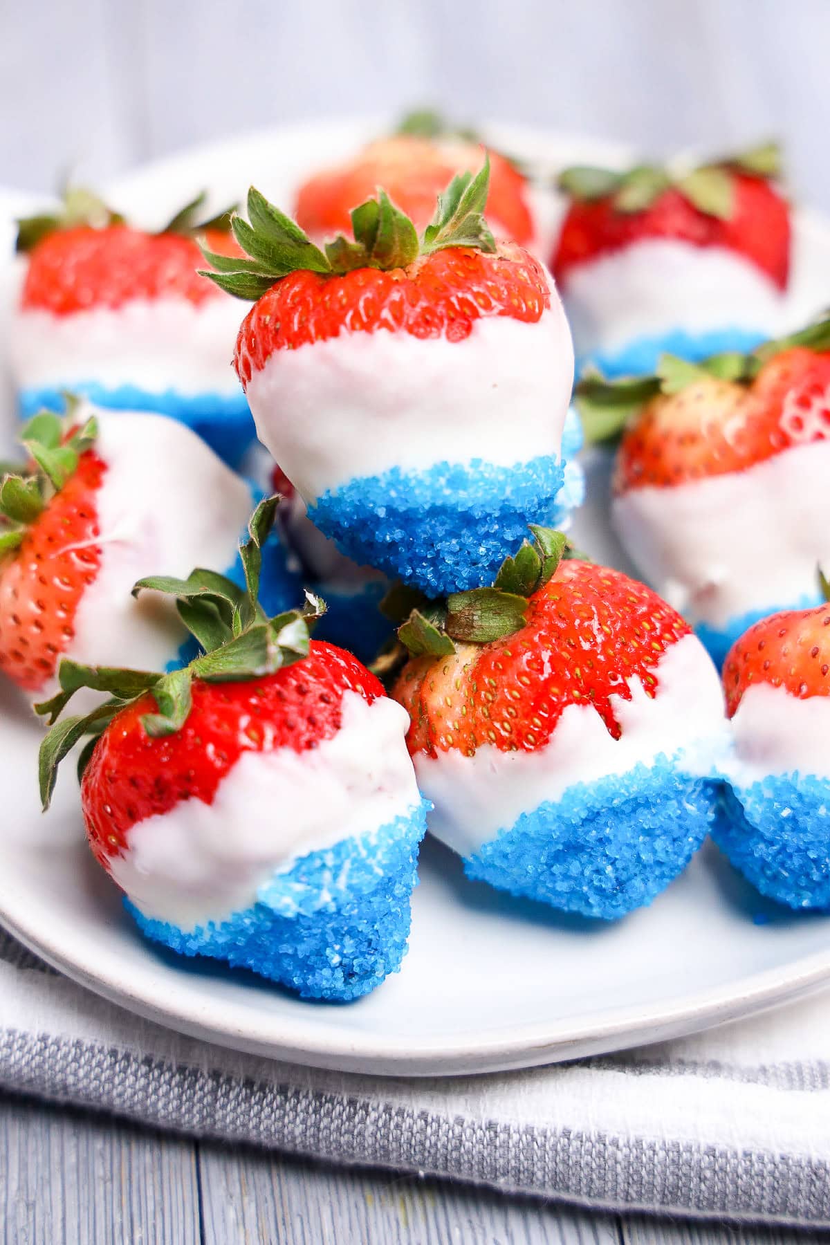 Fresh strawberries dipped in white chocolate and blue sanding sugar close up.