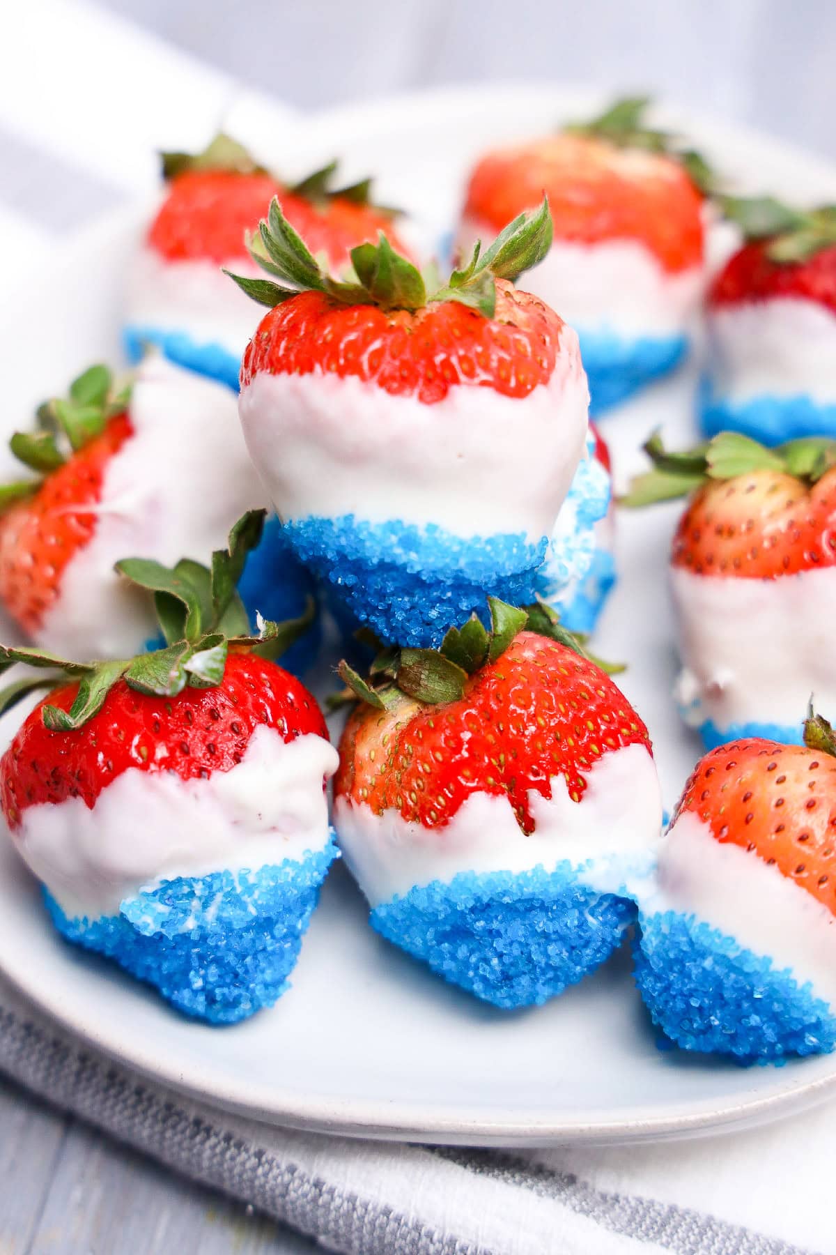 Patriotic dessert strawberries with white chocolate and bright blue sugar crystals.