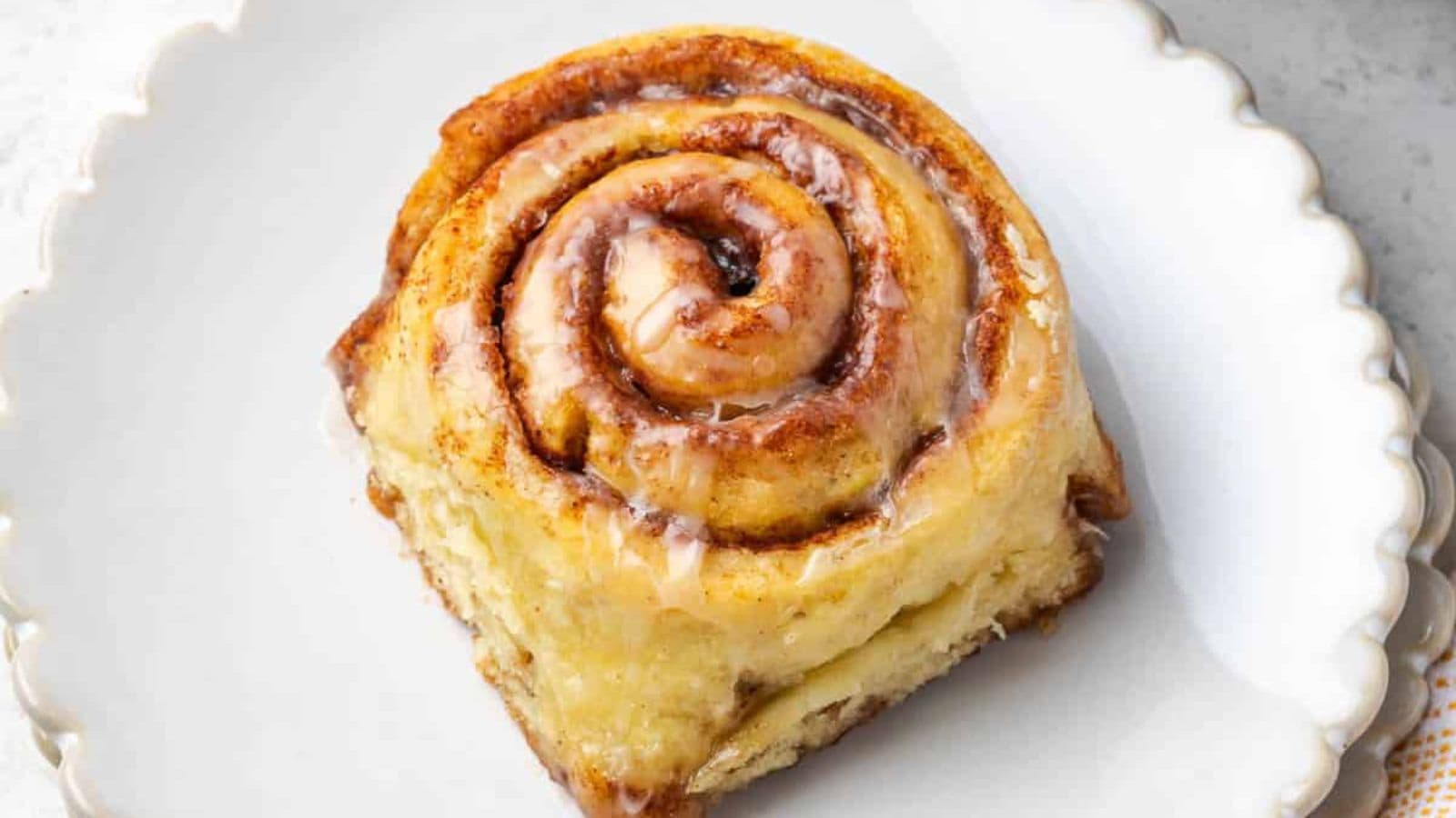 Orange cinnamon rolls with citrus-infused glaze and soft, fluffy layers.