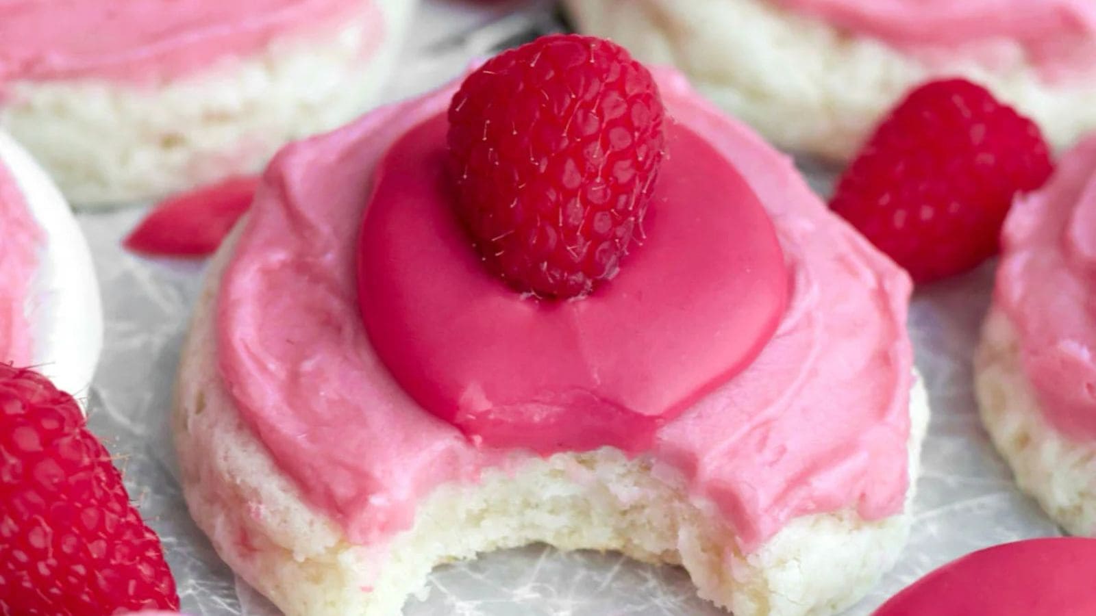 Raspberry cheesecake cookies with soft centers and swirls of berry and cream cheese.