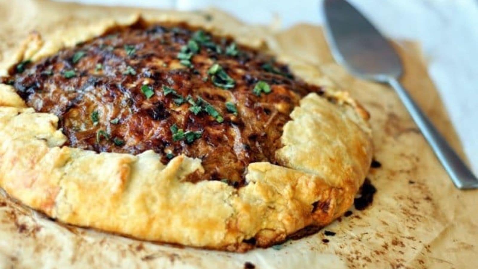 Rustic potato and caramelized onion tart with golden edges and savory filling.