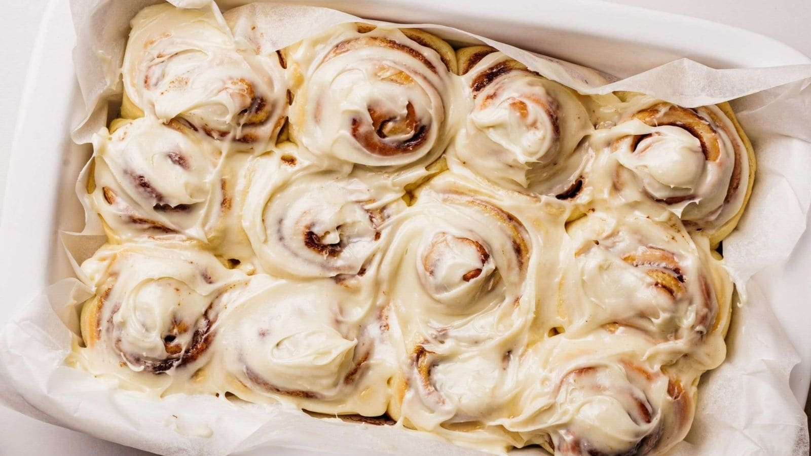 Classic cinnamon rolls with swirled filling and thick, creamy icing on top.