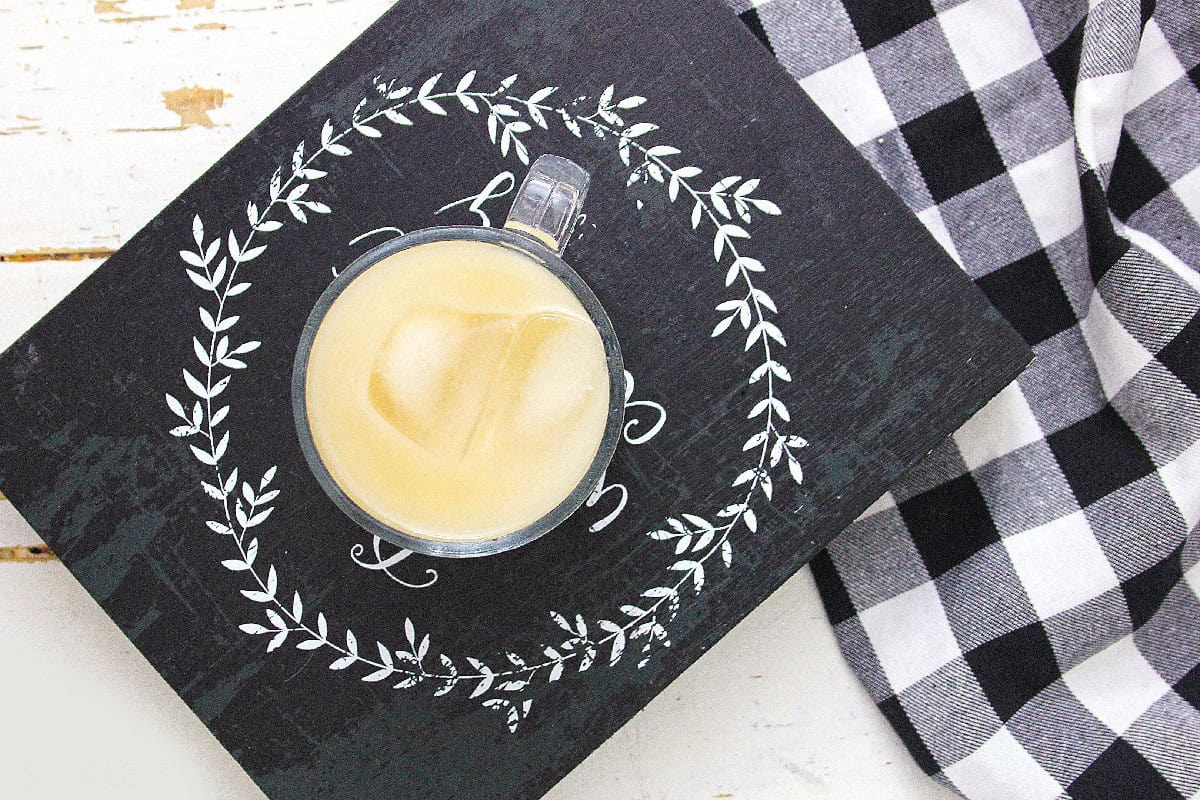 Top view of milk tea with ice and boba pearls in a glass mug.