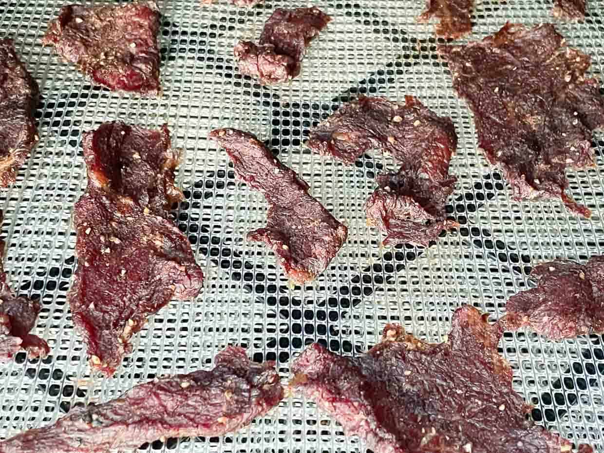 Beef jerky on a dehydrator rack.