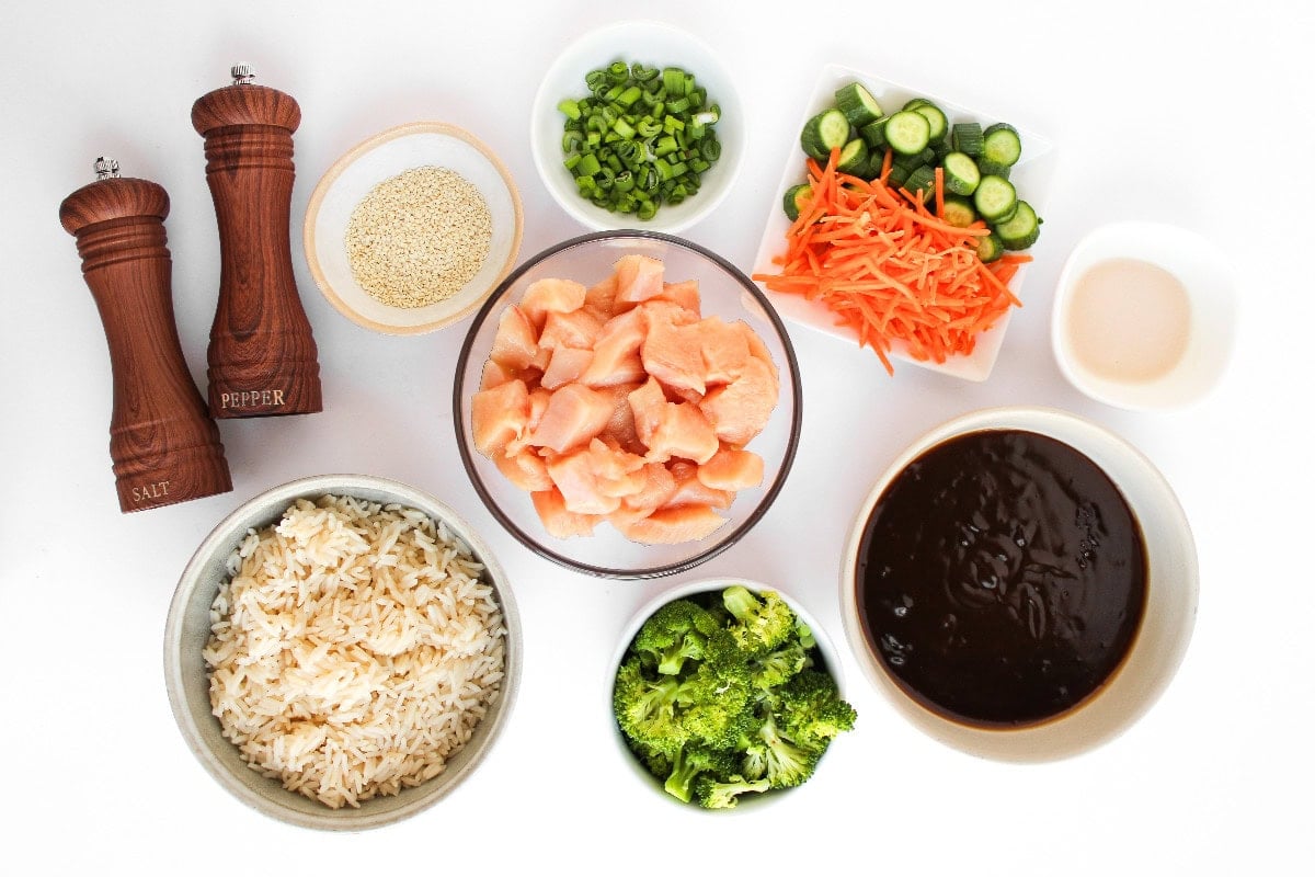 Raw chicken pieces with seasonings and ingredients prepared for teriyaki chicken bowl.