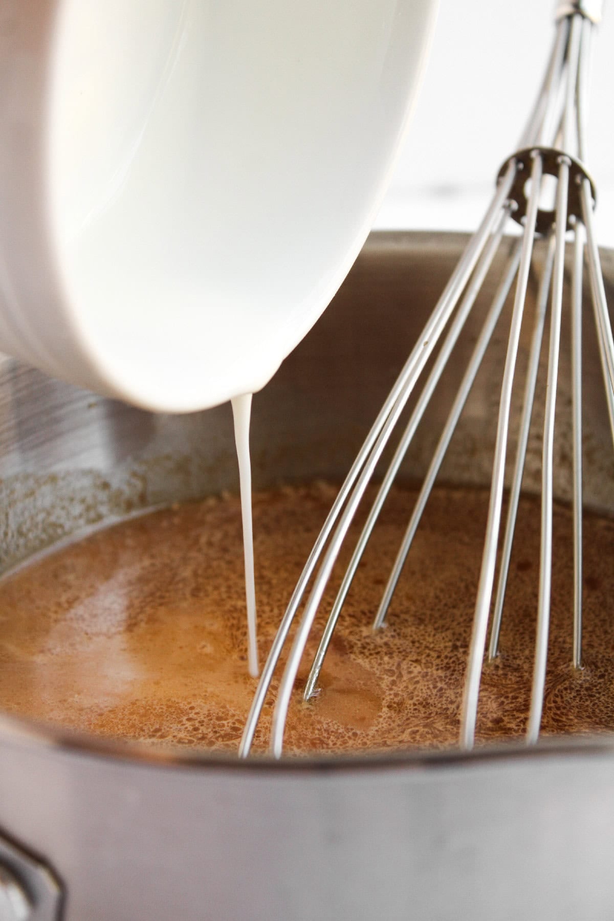 Cornstarch slurry in a small bowl for thickening sauce.