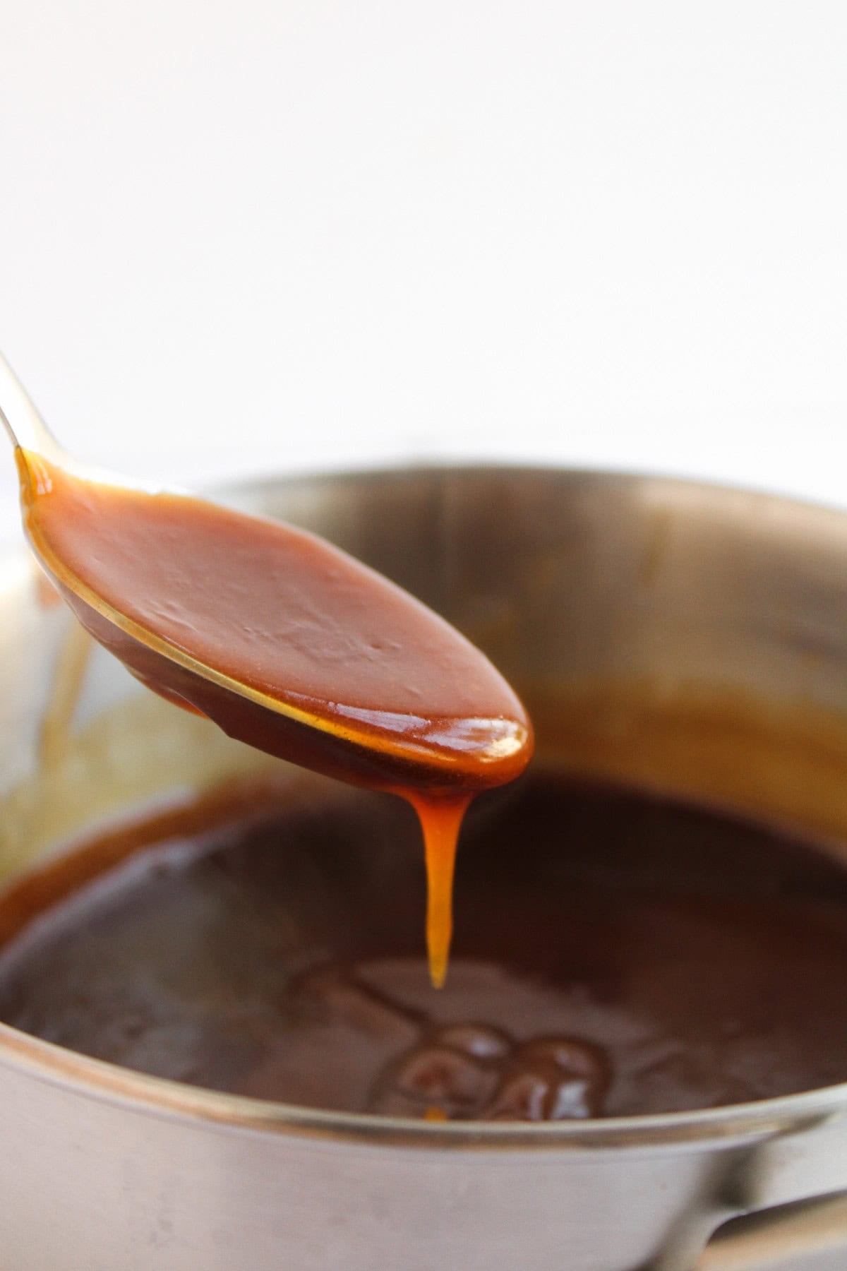 Thick teriyaki sauce dripping from a spoon.