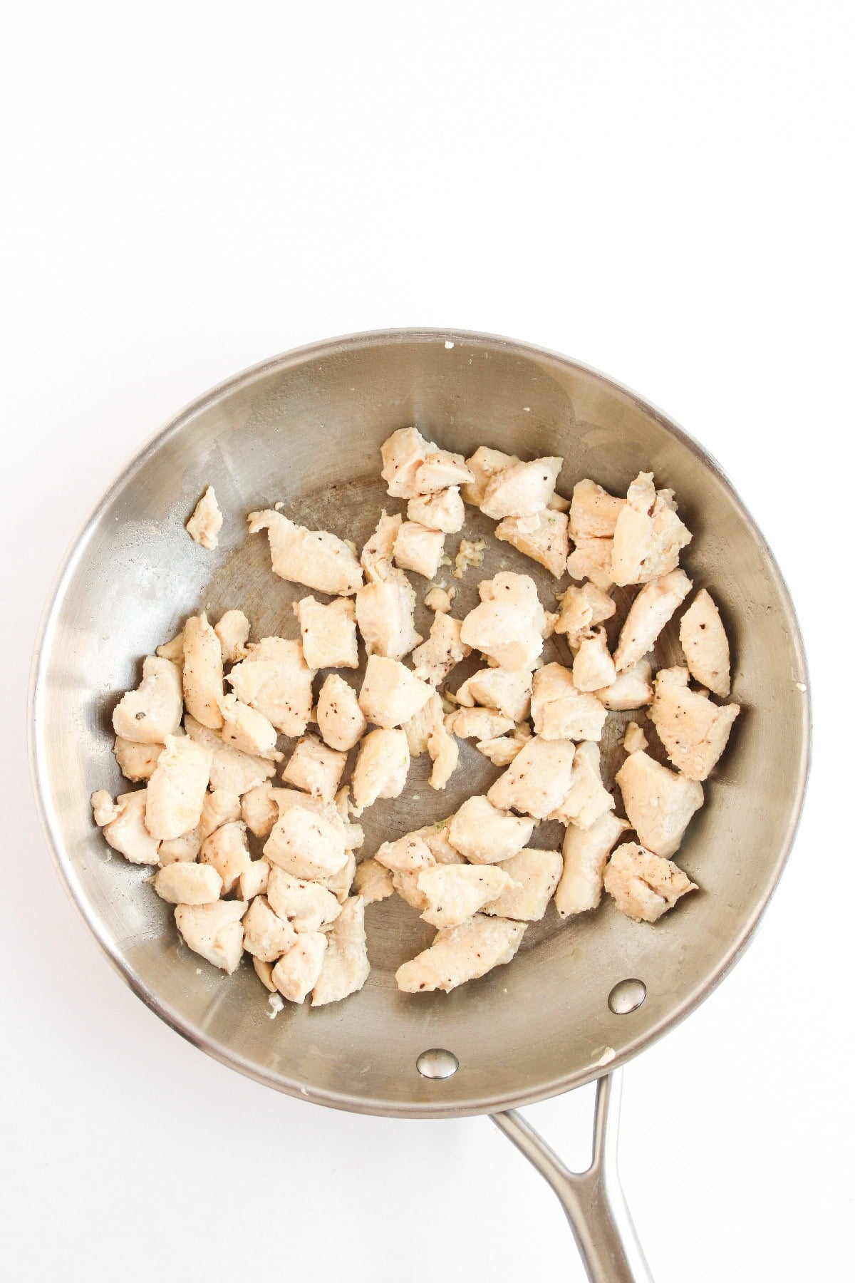 Cooked chicken pieces in a skillet.