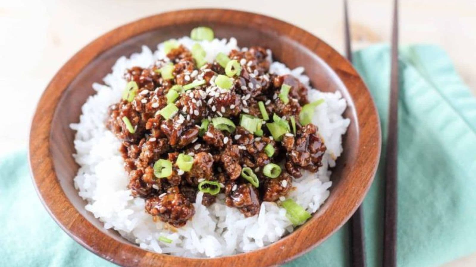 Chicken rice bowl topped with vegetables and flavorful sauce.