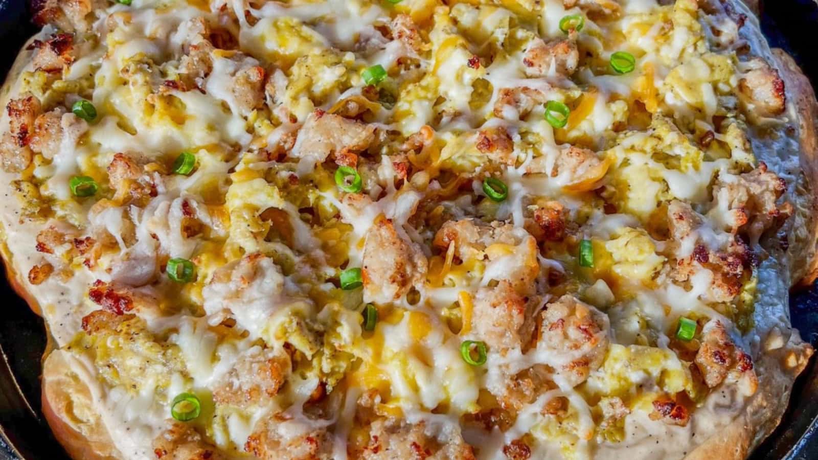 Breakfast pizza topped with biscuits, sausage gravy, and melted cheese.