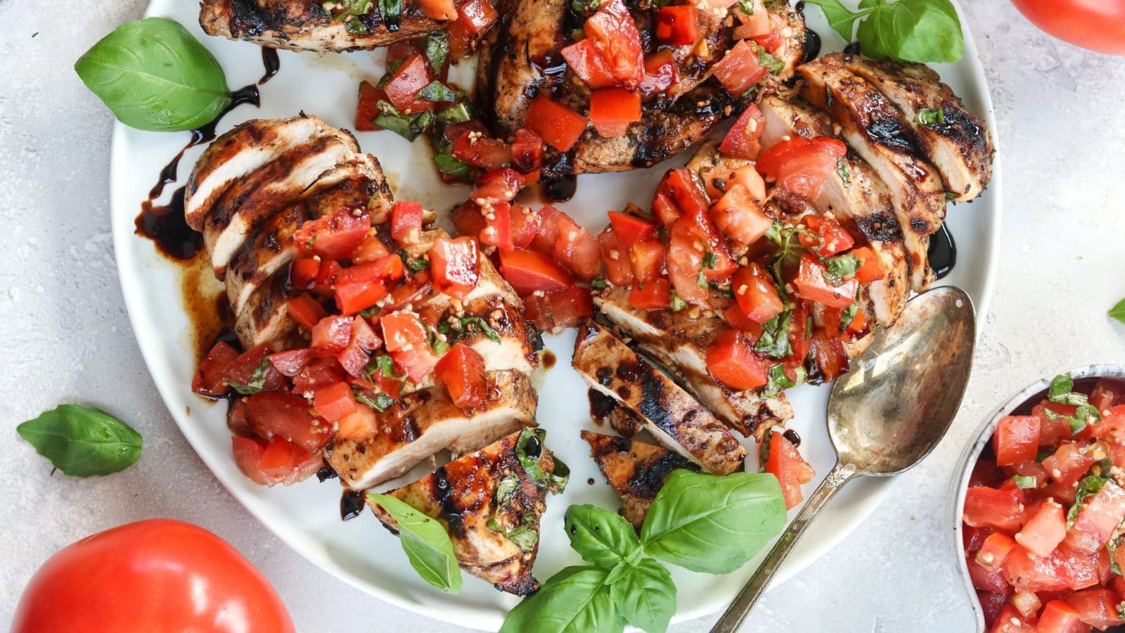 Grilled chicken topped with tomatoes and herbs in a bruschetta-style topping.