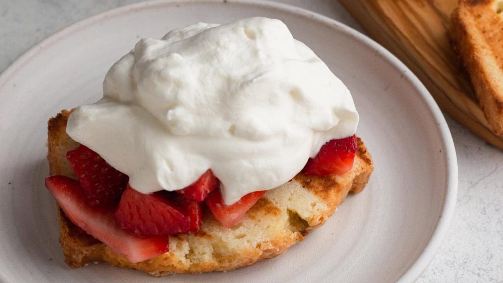 Strawberry shortcake topped with grilled strawberries and whipped cream.
