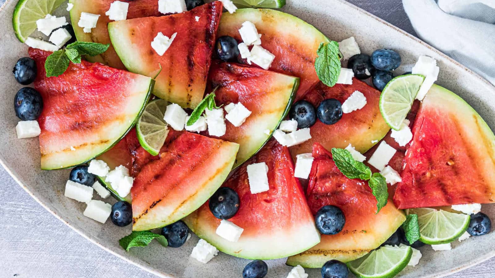 Watermelon salad grilled and topped with fresh savory ingredients.