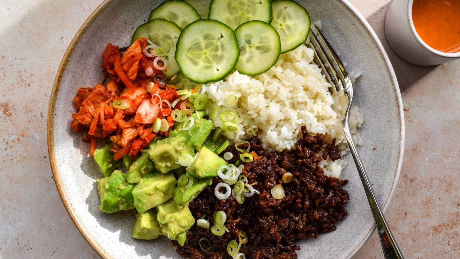 Korean beef rice bowls drizzled with spicy gochujang sauce.