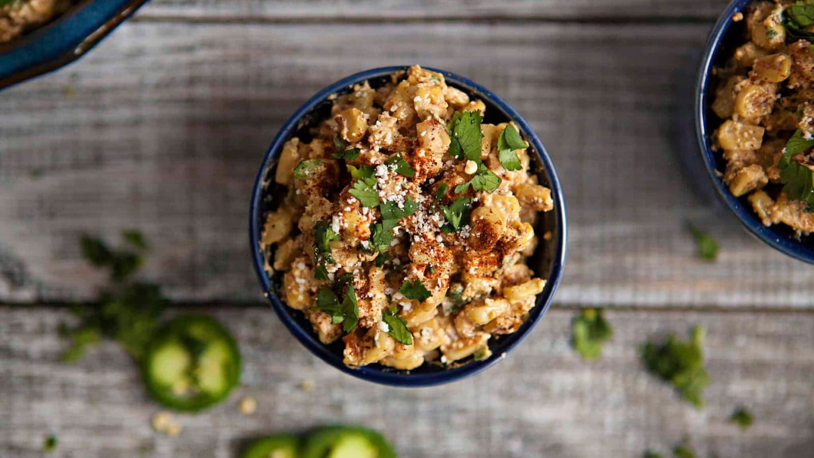 Street corn served in a cup with creamy toppings and seasoning.