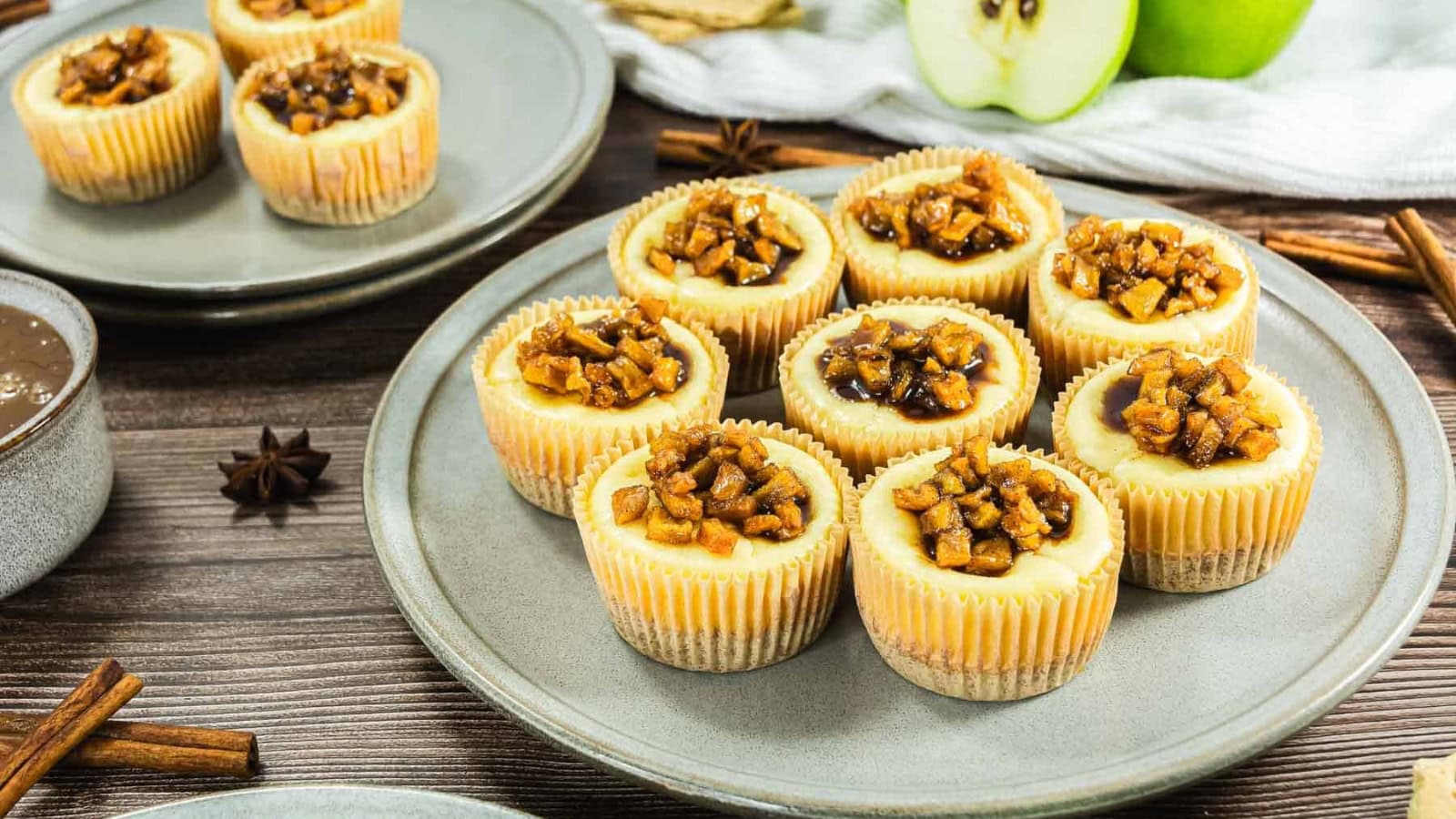 Mini cheesecakes topped with caramel and apple pieces.