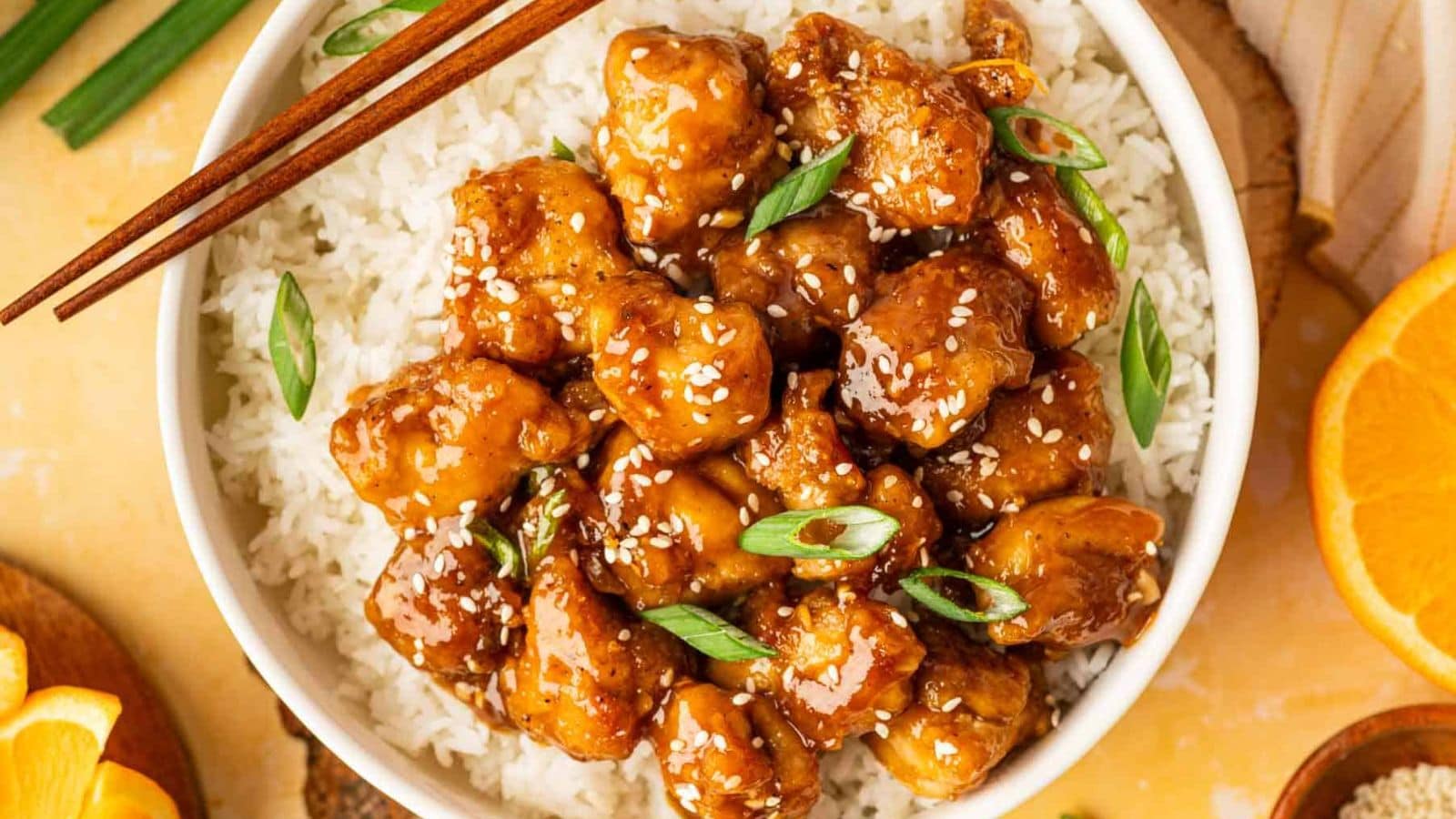 Orange chicken served with rice and coated in glossy citrus sauce.