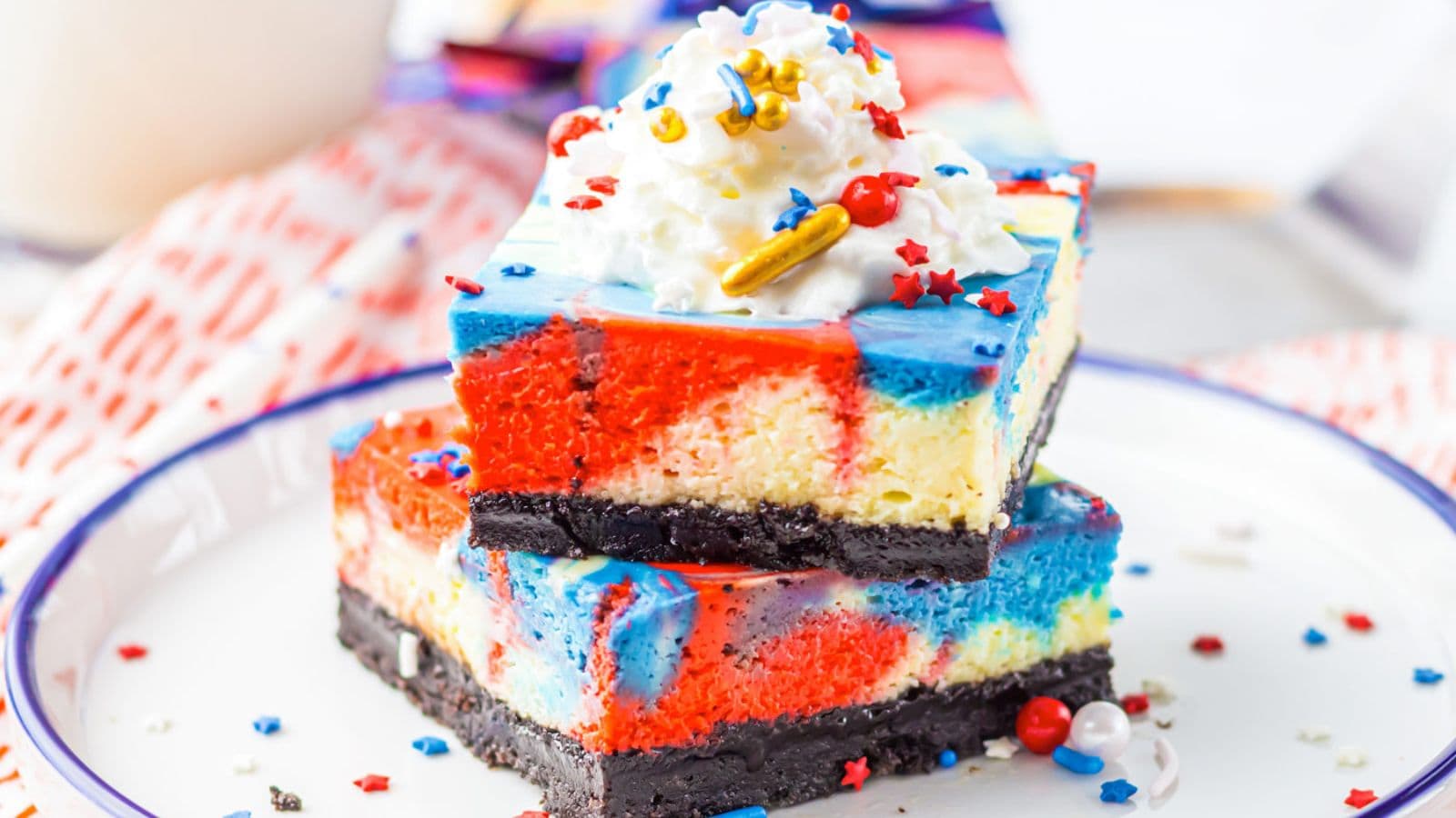 Cheesecake bars layered with red, white, and blue swirls on a buttery crust.