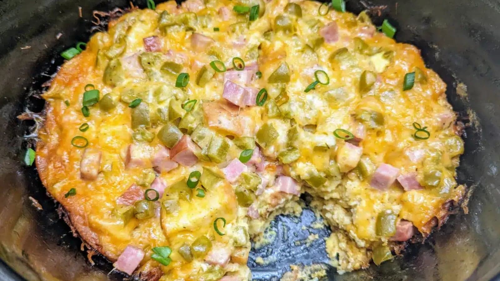Breakfast casserole baked with eggs, ham, peppers, and melted cheese.