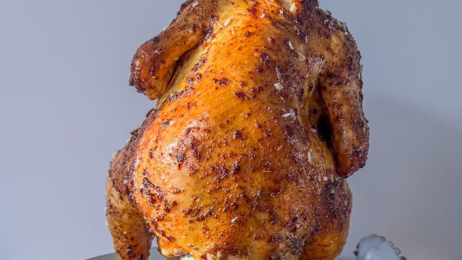 Beer can chicken smoked until golden with crispy skin and juicy meat.
