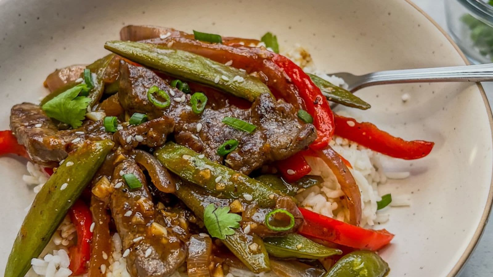 Orange beef stir fry coated in sticky sauce with tender beef slices.