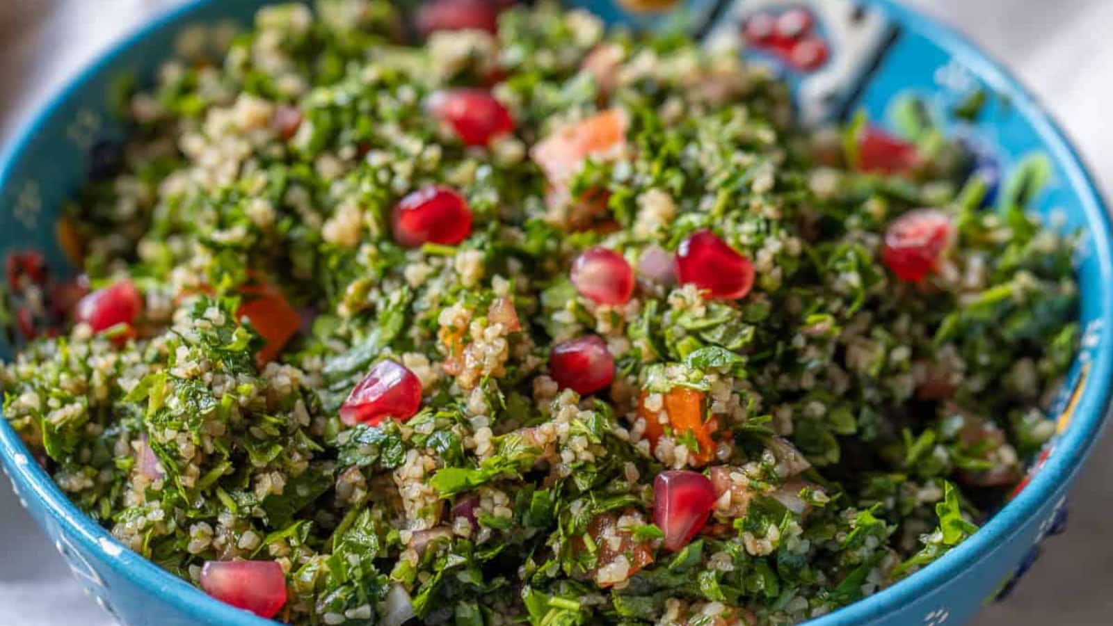 Tabbouleh salad mixed with parsley, bulgur, and fresh vegetables.