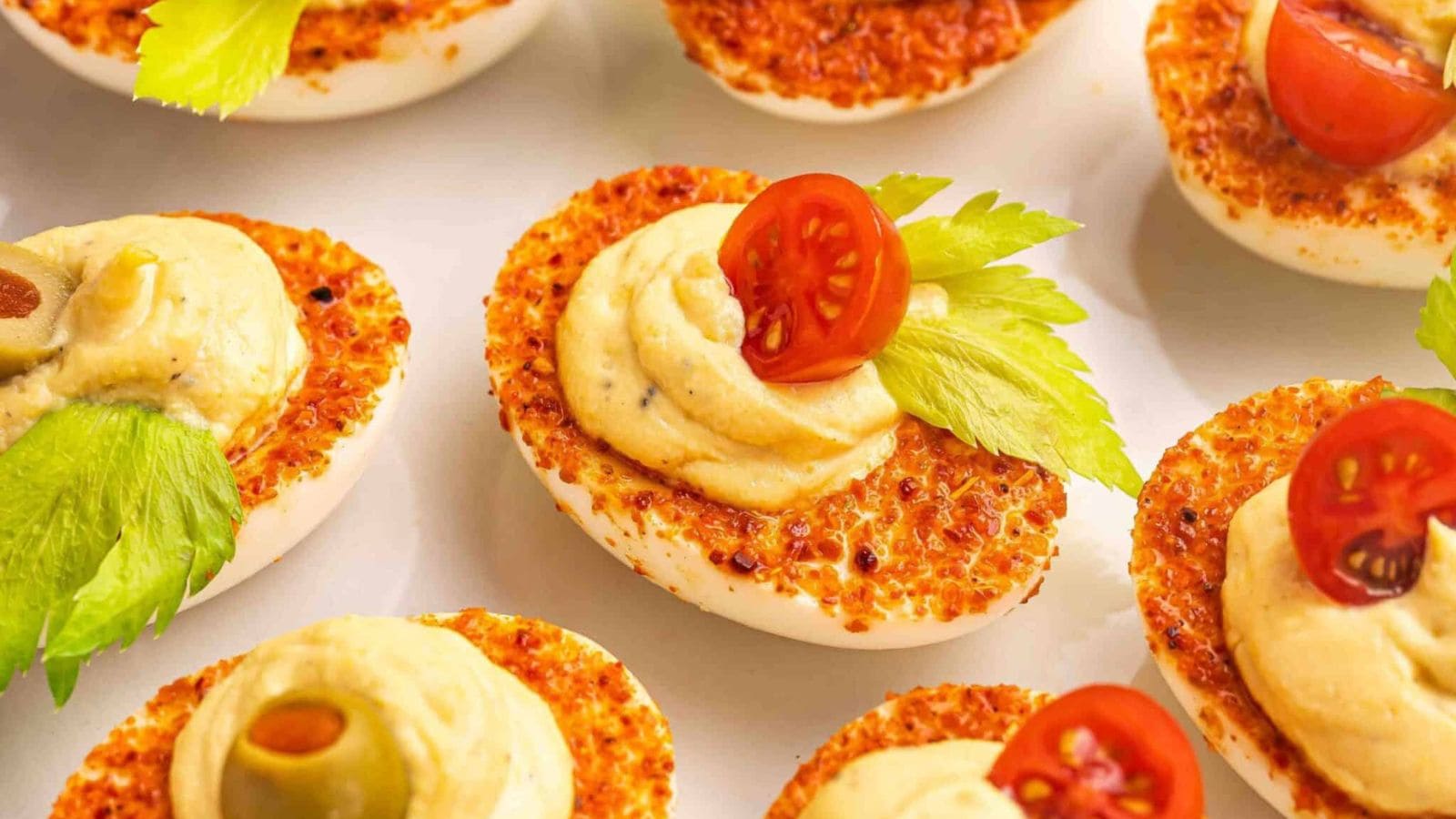 Deviled eggs topped with Bloody Mary-inspired seasoning and savory garnish.