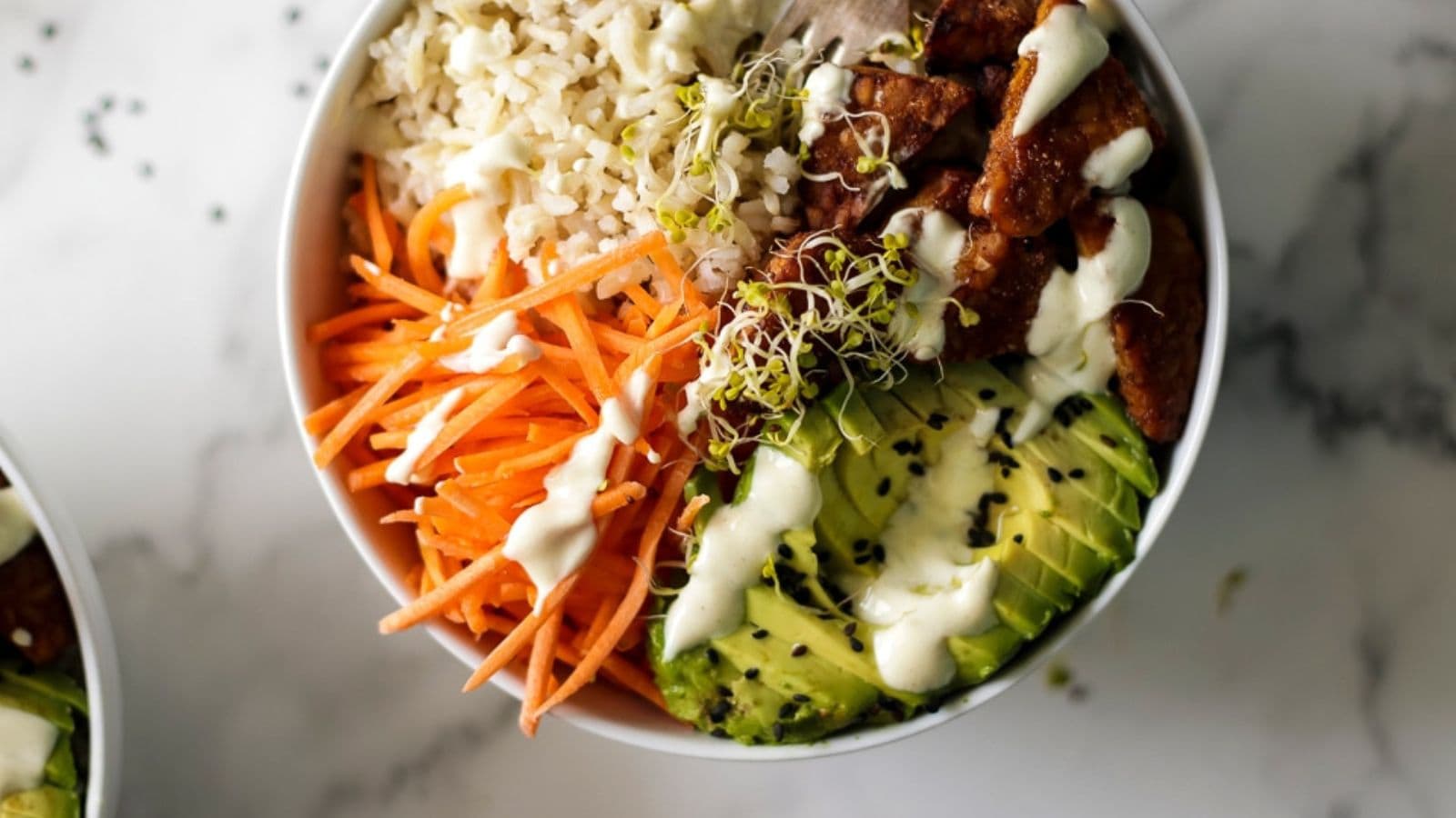 Vegan rice bowl layered with tempeh and colorful vegetables.