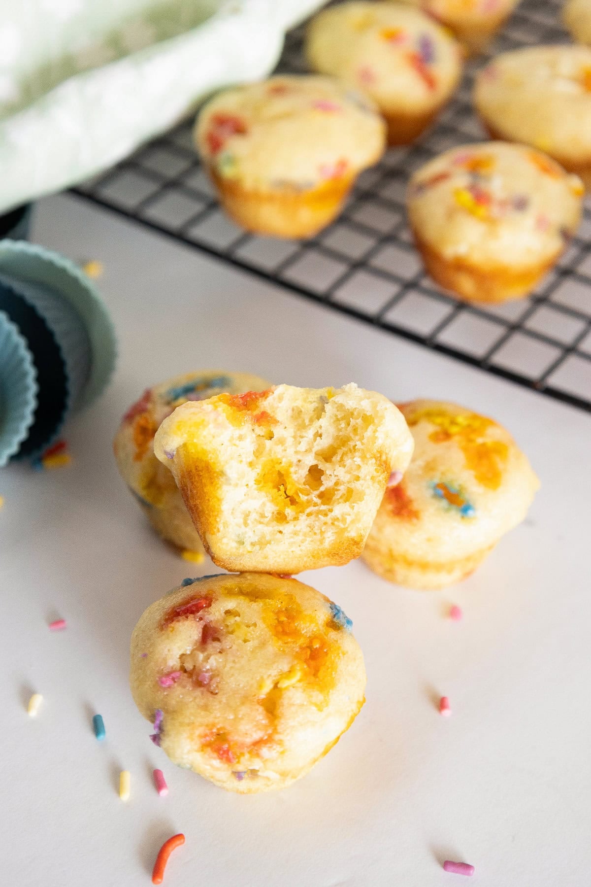 Close-up of a fluffy birthday cake mini muffin with colorful sprinkles and soft crumb texture.